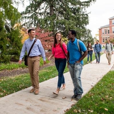 Three diverse students walking on a sidewalk at Cedarville